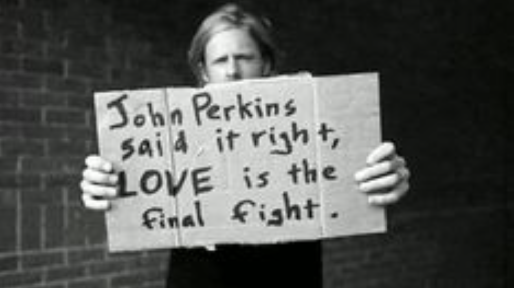 Jon Forman of Switchfoot with a sign citing the words of John Perkins.
